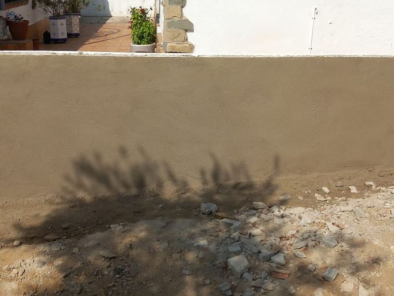 Muro de bloques terminado, enfoscado con mortero y con la coronación rematada